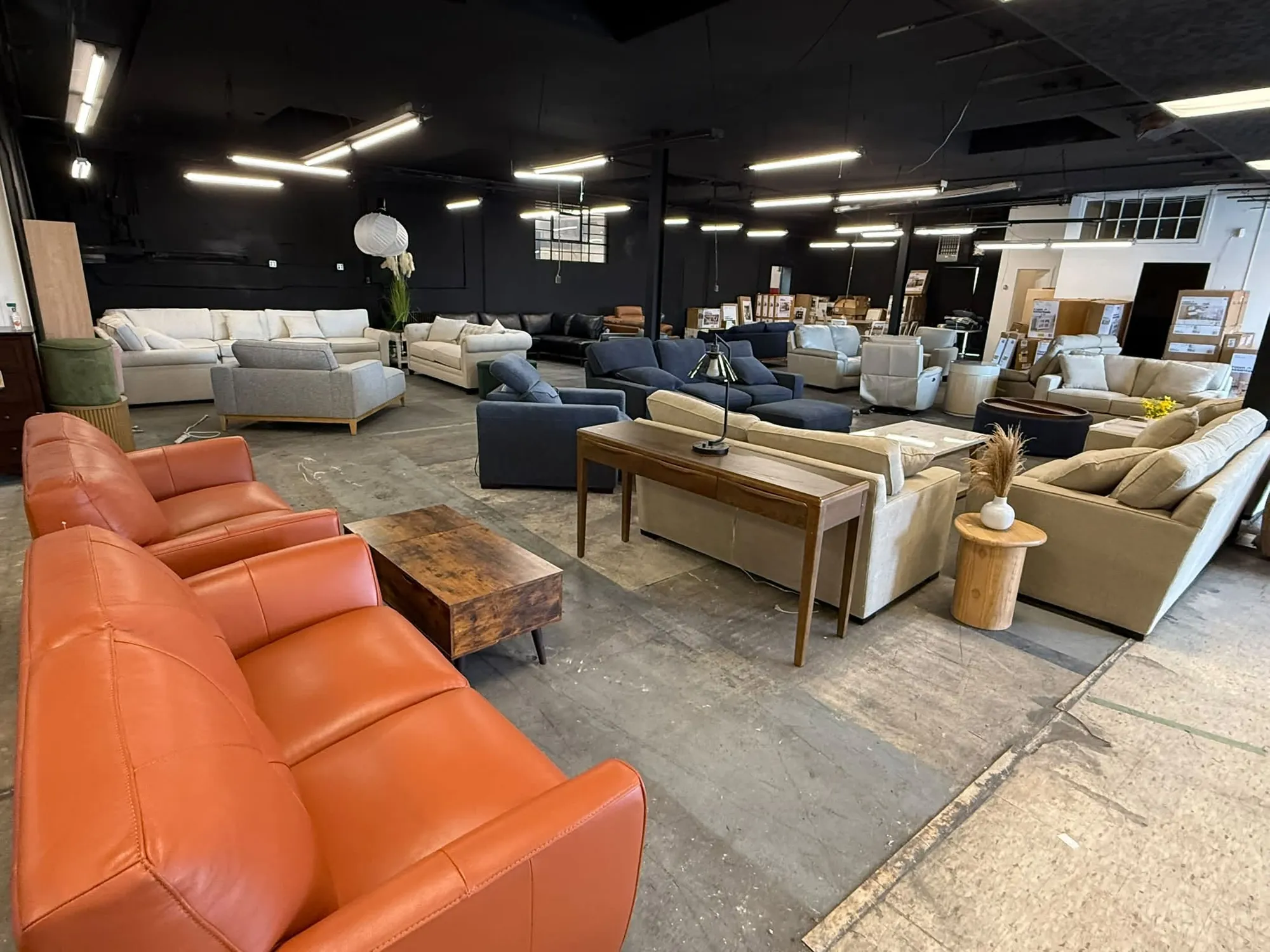 Rows of sofas, sectionals, and dining furniture on the showroom floor at Rebuilding Life Furniture in Harrisonburg VA